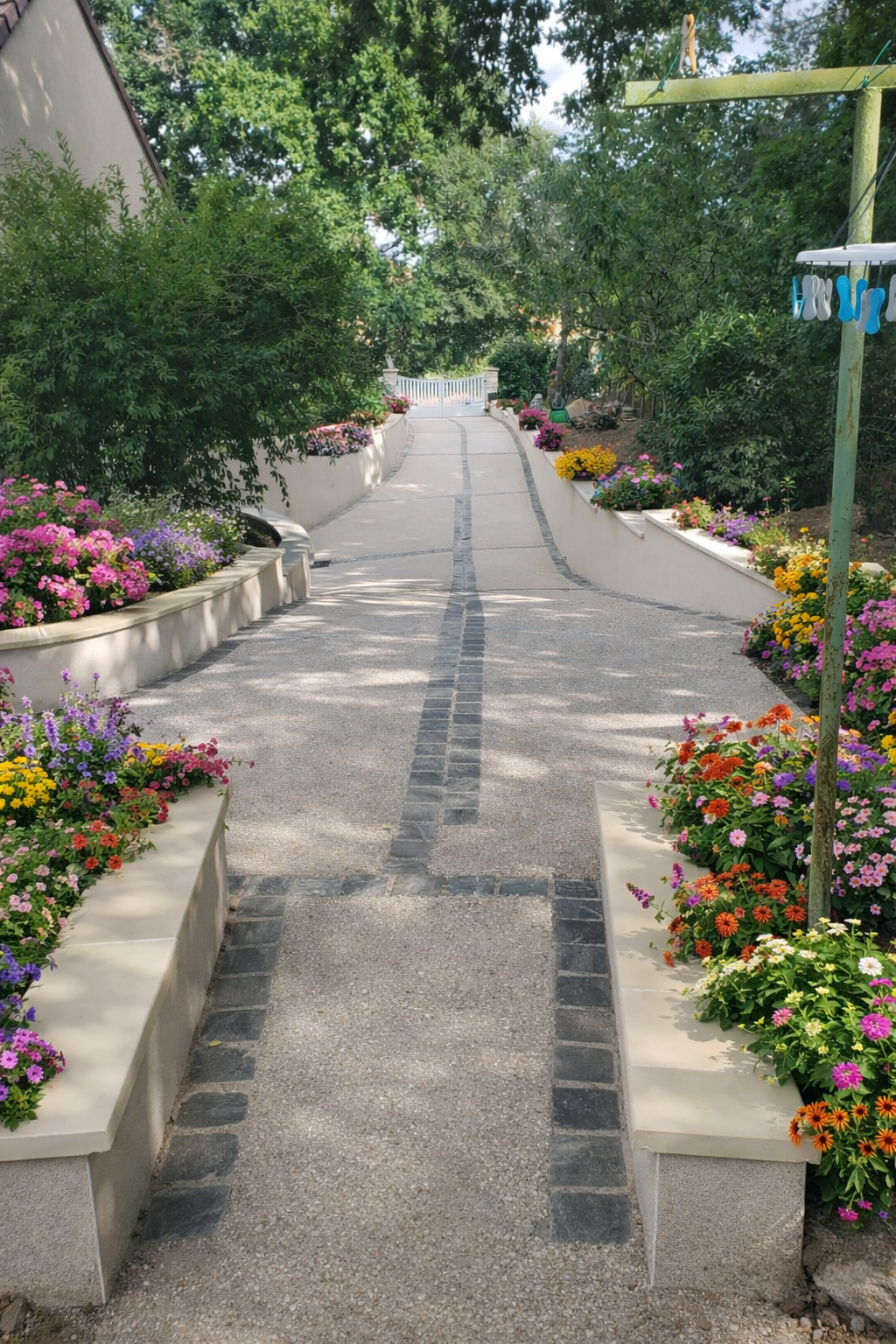 Allée extérieure aménagée avec pavés, fleurs et travaux paysagers réalisés par Batipereira à Neuvy-sur-Loire